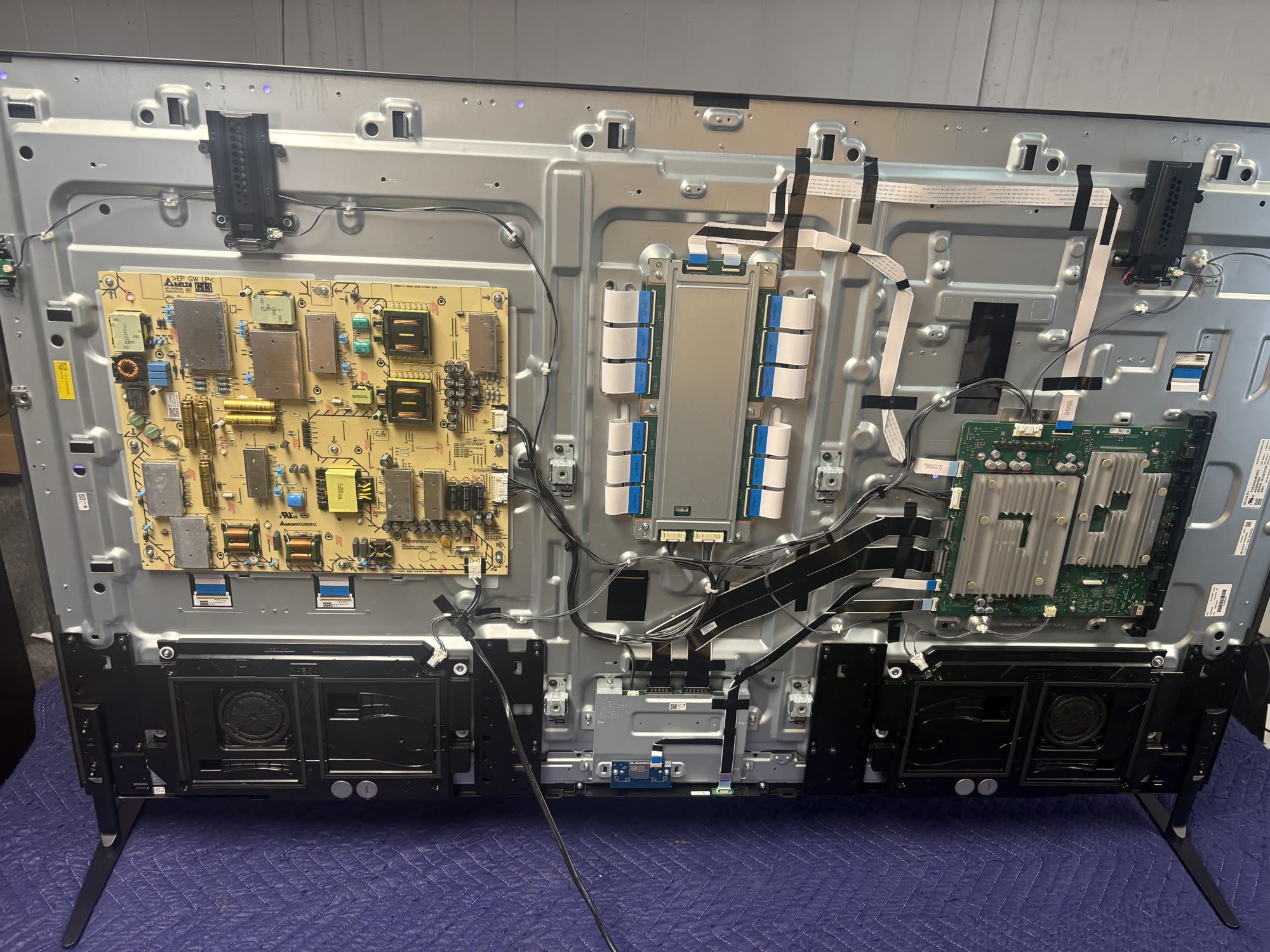 TV back panel open showing power board and main board during repair